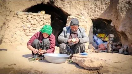 (ویدئو) پخت نان محلی ساجی و خورشت گوجه بادمجان توسط زوج عاشق غارنشین افغان