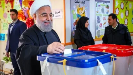 شوخی حسن روحانی با 2 رای دهنده جوان و عکس یادگاری با متصدیان صندوق رای/ ویدئو
