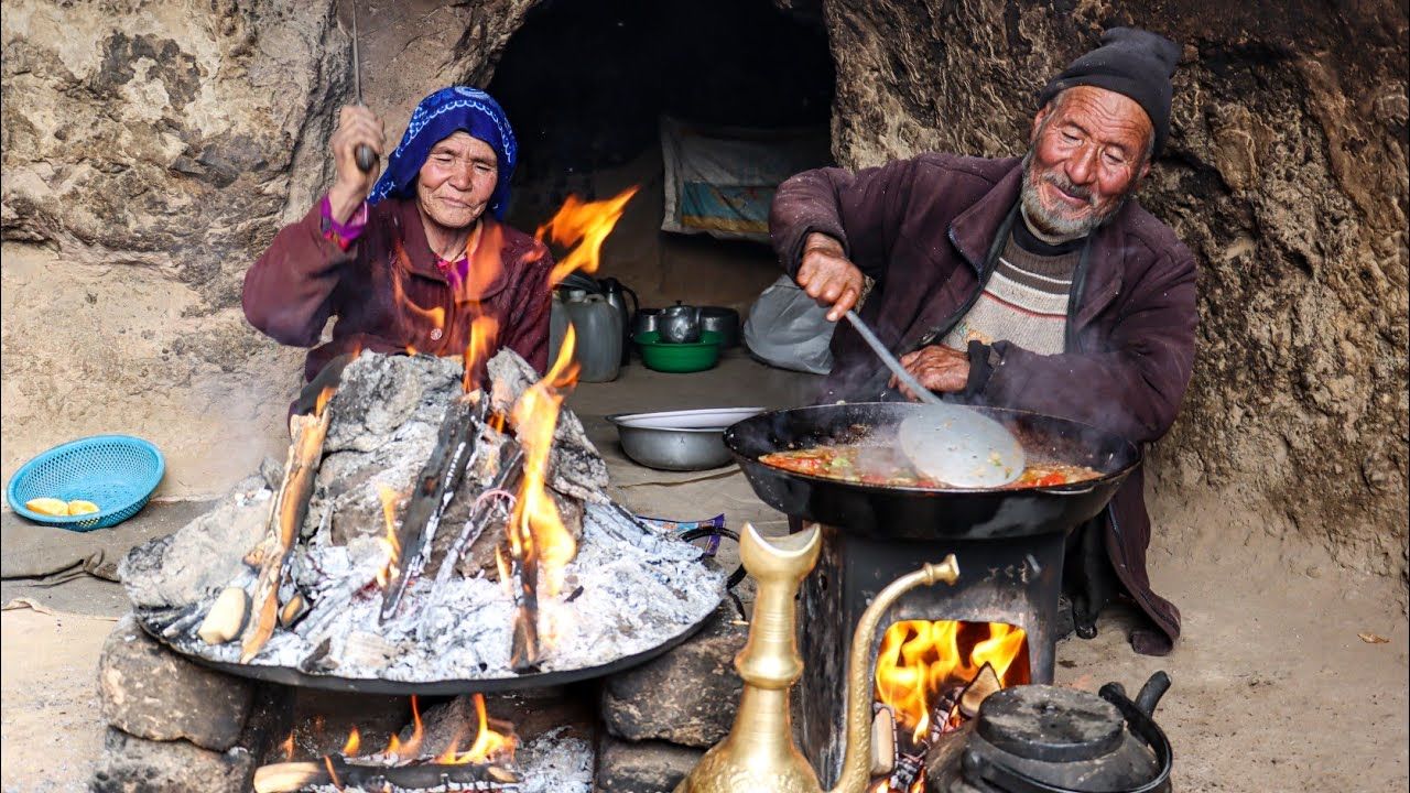 (ویدئو) پخت مرغ گلی روی ساج یه شیوه تماشایی یک زوج عاشق غارنشین افغان