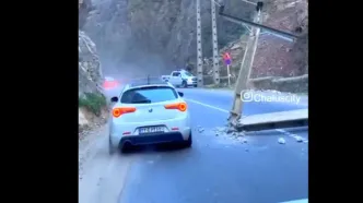 ببینید / افتادن تیر چراغ برق وسط جاده جاده چالوس