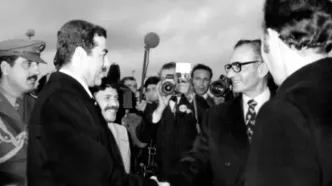 ژست مغرورانه شاه و صدام در عقب یک خودرو