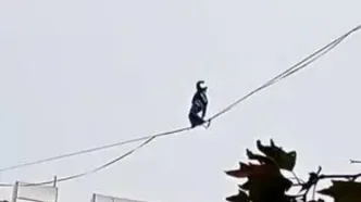 حرکت خطرناک دختر جوان روی سیم‌های معلق بین ساختمان/ویدیو