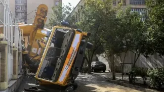 واژگونی جرثقیل به یک مدرسه و ۳ خودرو در تهران خسارت زد/ راننده مصدوم شد