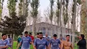 آبیاری کشتی‌گیران با شلنگ باغ‌بانی توسط دبیر