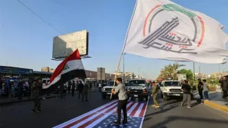 دفتر نخست وزیر عراق: عاملان توهین به پرچم آمریکا در رژه حشد الشعبی بازداشت شدند/ تصاویر