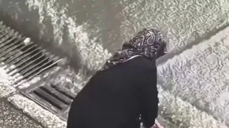زن سالمند با عصا به داد خیابان‌های آب‌گرفته رسید